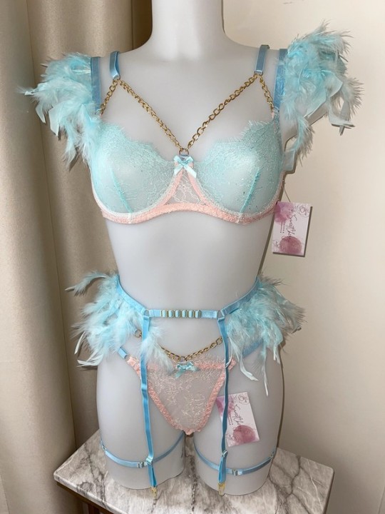 Ensemble de lingerie sexy en dentelle trois pièces dans les couleurs bleu clair et rose, comprenant des plumes.